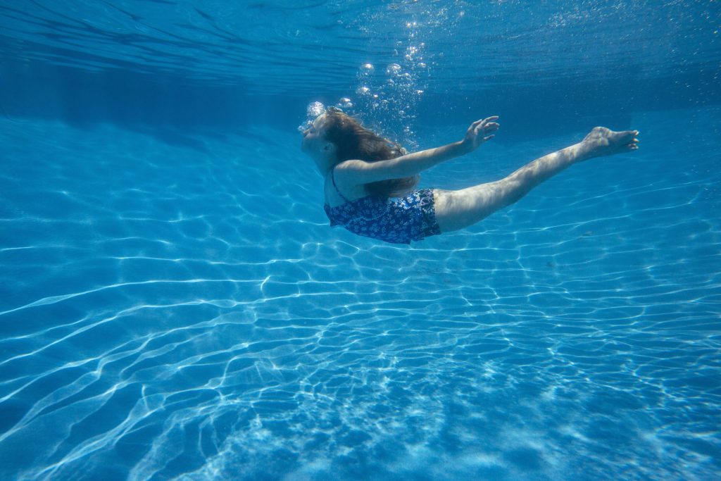 a-child-swimming-under-water-in-a-swimming-pool-4wlll97-scaled-1024x683