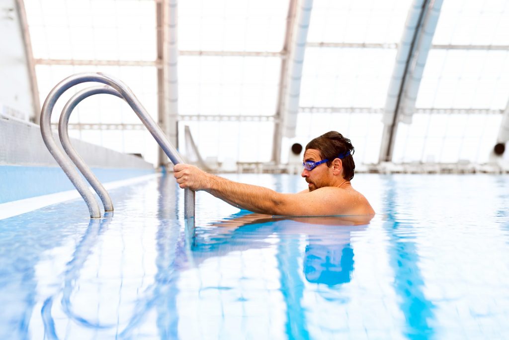 man-swimming-in-an-indoor-swimming-pool-pu9yt8j-scaled-1024x683